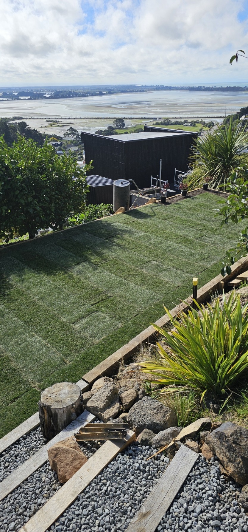 Hillside lawn and landscaped garden overlooking the estuary