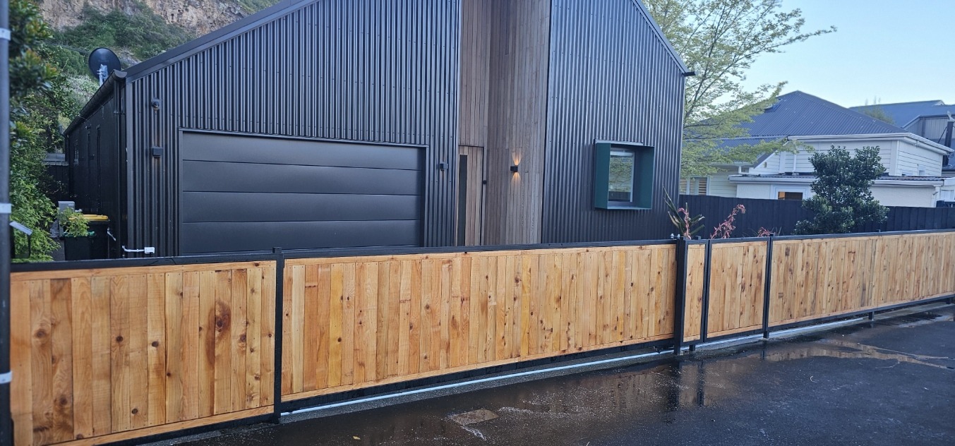 Cedar and steel boundary fence outside a modern black home